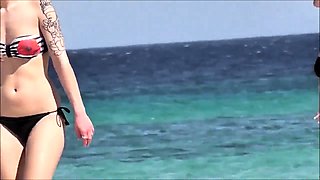Beach voyeur films a sexy amateur brunette in a black bikini