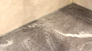 Anong Cleans the Bathroom Floor with Her Soaked Hoodie, on Her Knees.