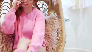 Petite brunette in pink sweater enjoys phone sex
